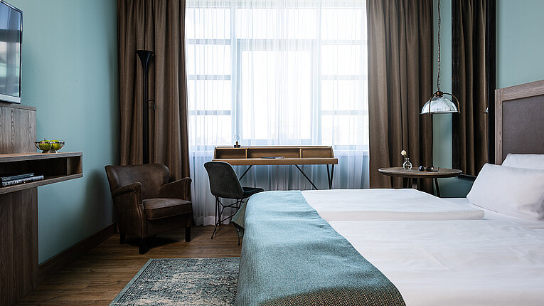 AMERON Hotel ABION Spreebogen Berlin Standard Zimmer mit Bett Frontal Schreibtisch und Fenster